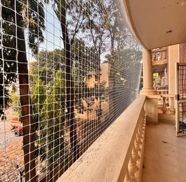 Installation team fitting sports nets on a local Bangalore playground under a clear blue sky.