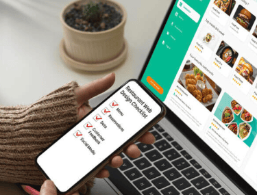 A hand holding a phone displaying a restaurant web design checklist next to a laptop showing a food delivery app interface.