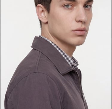 A male model wearing a casual dark grey zip-up jacket over a checkered shirt.