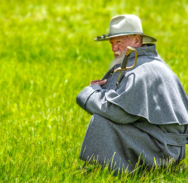 Photo of civil war soldier squating in the grass