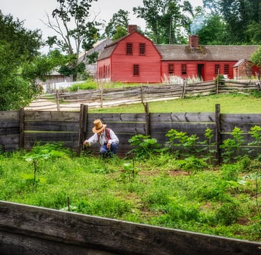 Photo of historically dressed farmer and red barn