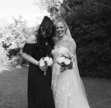 Bride and bridesmaid laughing while holding bouquets at Fredricks Hotel & Spa, Berkshire