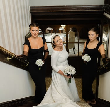 Bride and bridesmaids in a stairwell holding bouquets during wedding portraits