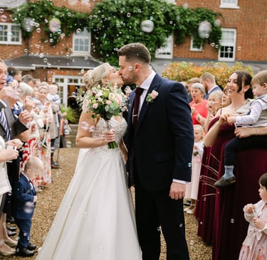 Couple kissing during bubble aisle shot at The Mill House Hotel