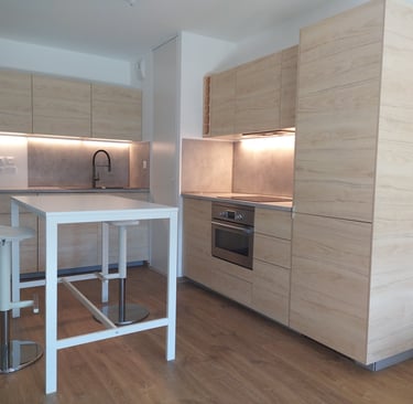 Cuisine conçue et montée appartement neuf à Tours façades aspect hêtre plans de travail ciment