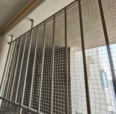 Window protected by a fine mesh pigeon net, ensuring ventilation without bird intrusion.