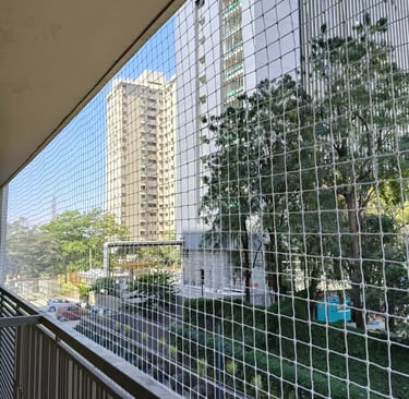 Wide shot of a residential apartment balcony fully covered with pigeon netting to keep birds out.