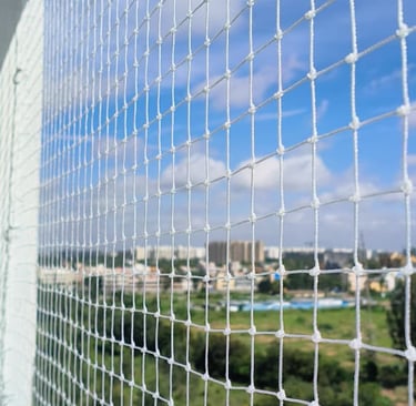  high-rise balcony in Wadala secured with Arjilli Safety Nets, with a clear blue sky background.