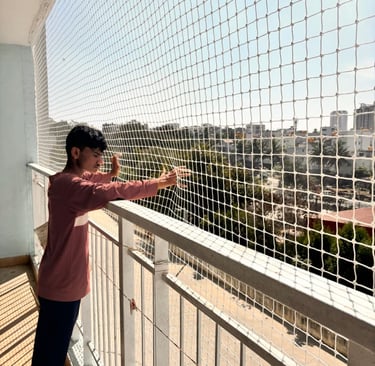 Technician installing durable pigeon netting on a balcony in a busy Mumbai neighborhood.