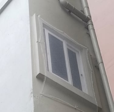 Pigeon net installed around an AC outdoor unit, blending seamlessly with the building facade.