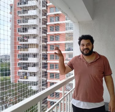 Wide shot showing a high-rise building with multiple balconies fitted with safety nets