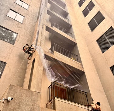 Wide-angle view of a spacious balcony fitted with durable safety nets overlooking the city skyline