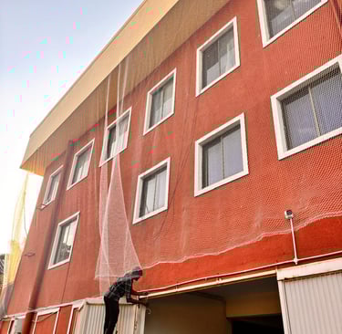 Duct area pigeon net fitted in high-rise apartment to prevent pigeons and droppings.