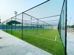 Wide-angle view of a spacious terrace covered with tightly woven safety nets, sunlight casting shado