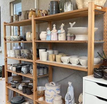 a shelf with many different types of potteryware