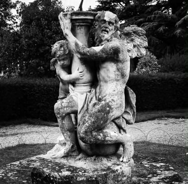 A black and white photo of a sundial statue with Father Time and a cherub