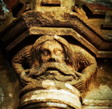 a carved figure on a stone column depicting a wild man or woodwose