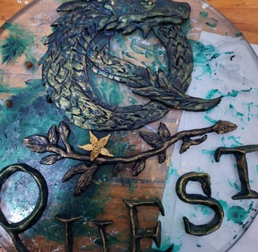 Hand-painted dragon sculpture and Quest sign art with metallic green and gold details on a glass base.