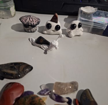 Handmade clay mushoom and snail figurines with crystals and gemstones still to be used.