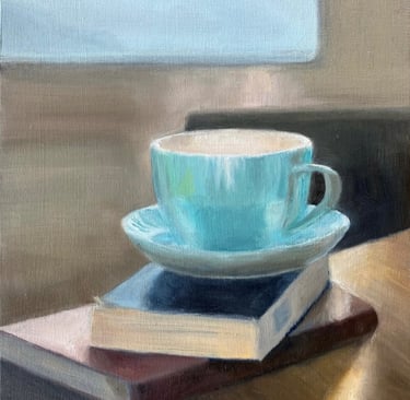 An original oil painting of cup and saucer on books in front of a sunlit window