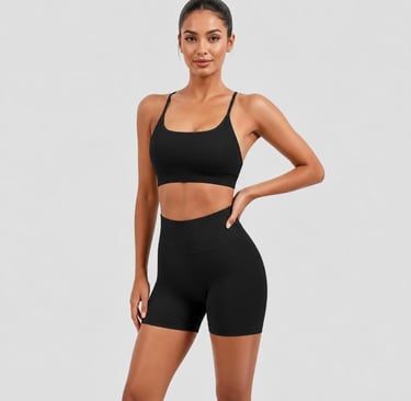 Woman wearing a matching black sports bra and high-waisted biker shorts with a light gray background