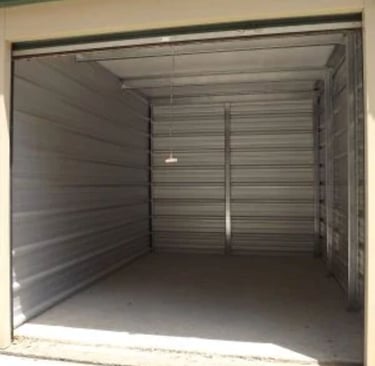 An empty 10X15 foot clean self-storage unit with metal walls and a concrete floor.
