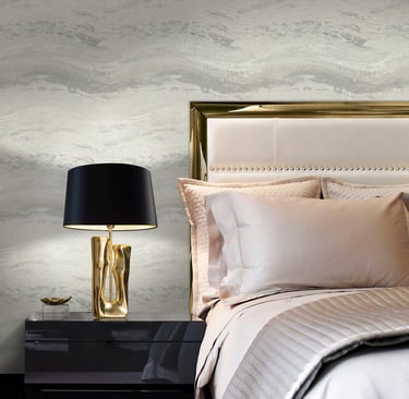 Luxury bedroom with grey marble wallpaper, gold headboard, and black designer bedside lamp.