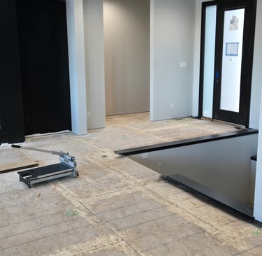 A vinyl plank floor cutter sits on a subfloor during a modern home interior renovation.