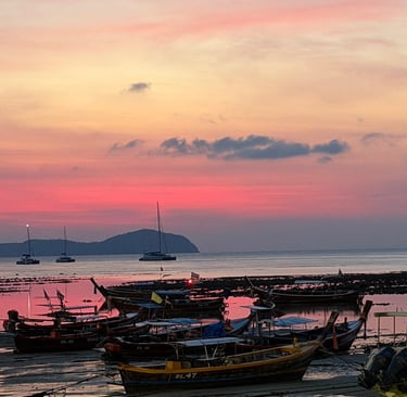 Sunset view over Rawai Beach with traditional Thai longtail boats near Yanui Apartments