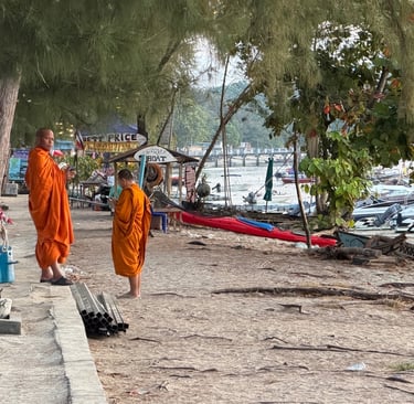 Buddhist monks in orange robes walking near the beach in Rawai Phuket