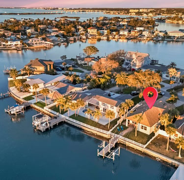 Aerial view of waterfront real estate in Florida with a red location pin marking a luxury home.