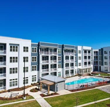 Courtyard pool area surrounded by four-story apartment buildings at a market-rate community in Morehead City, NC.