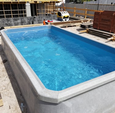 A backyard featuring a newly constructed swimming pool and garden shed.