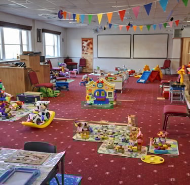 Play area inside New Life Church baby & toddler group in Saffron Walden with toys, soft play, slides and seating for parents.