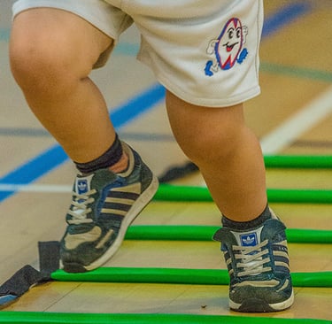 Toddler taking part in Ruggerbugs sports class in Saffron Walden indoor hall