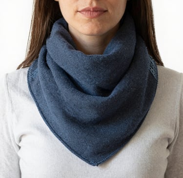 Close-up of a colorful handmade snood scarf draped elegantly on a rustic wooden chair.