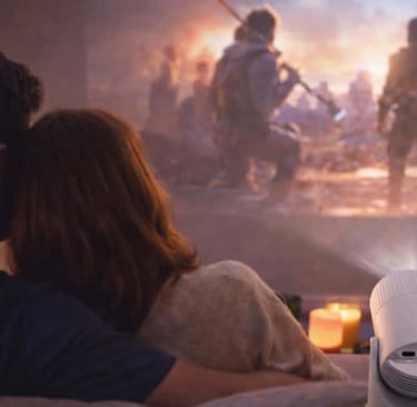 Couple watching a movie projected on the wall using a compact home projector