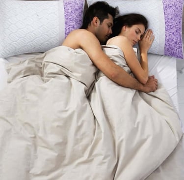 Couple sleeping closely together with supportive pillows for comfortable side sleeping