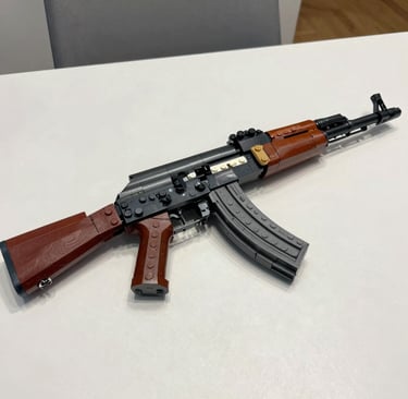 Detailed replica of an AK-47 rifle made from toy building blocks on a white table.