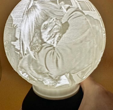A 3D printed lithophane globe lamp showing a detailed portrait when illuminated from within.