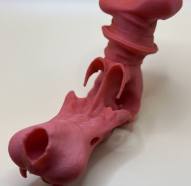 Red 3D printed dragon head figurine with detailed scales and a curved top piece.