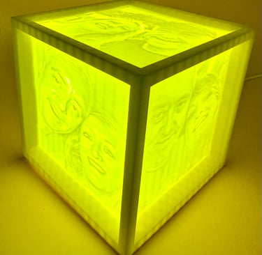 Custom 3D printed lithophane photo lamp cube with yellow LED light showing glowing family portraits.