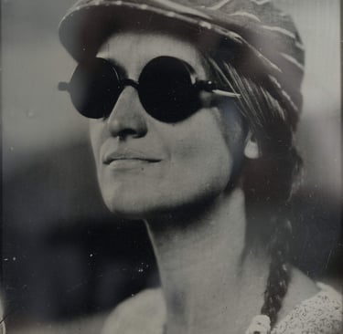 jeune femme blonde souriante posant de 3/4 face avec des lunettes rondes et un béret