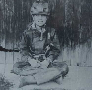 jeune fille habillée en spéléologue posant assise contre une porte