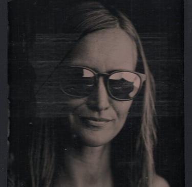 jeune femme blonde posant dans la pénombre avec des lunettes de soleil