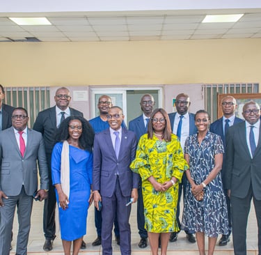 A group of professional business executives in formal suits and dresses posing for a corporate group photo.