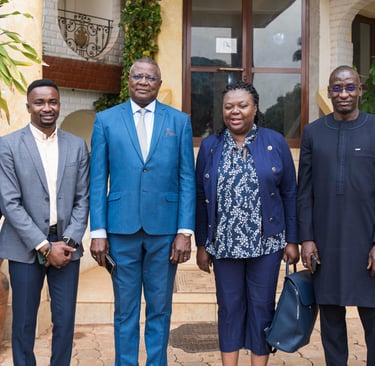 Professional group of African business leaders posing together outdoors in formal attire for a corporate event.