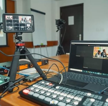 Professional live streaming setup featuring a laptop, video switcher, and monitor for a virtual conference.