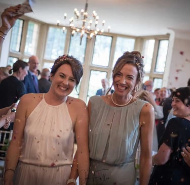 two brides walking down isle with confetti