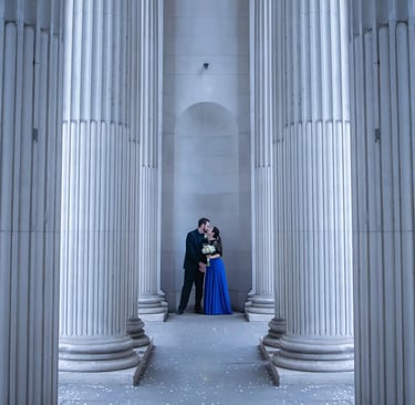 a man and woman standing in a room with columns